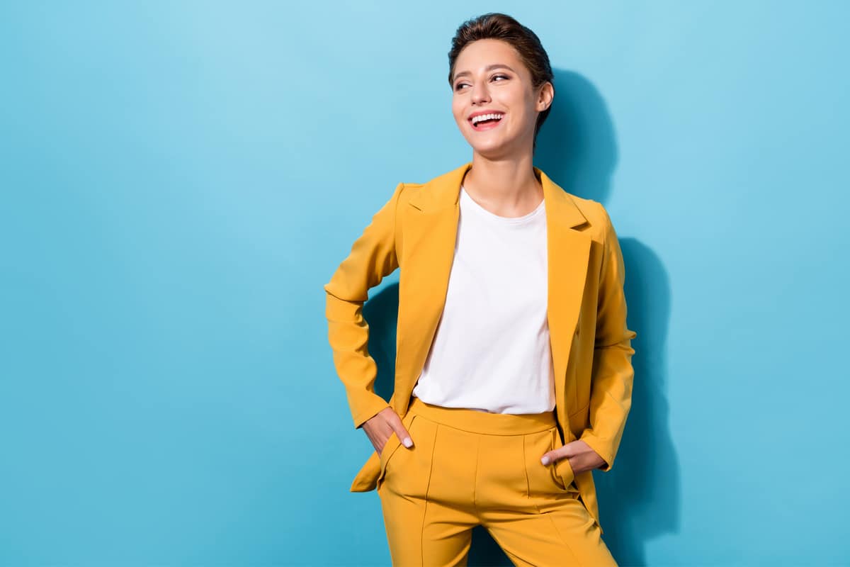 Armocromie : jeune femme dans un tailleur jaune sur fond bleu ciel